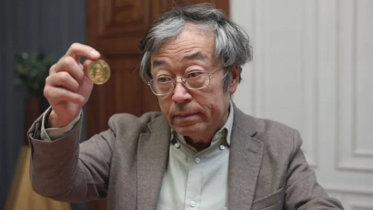 Imagem-satira-de-Dorian-Nakamoto-observando-bitcoin-na-mao-768x432